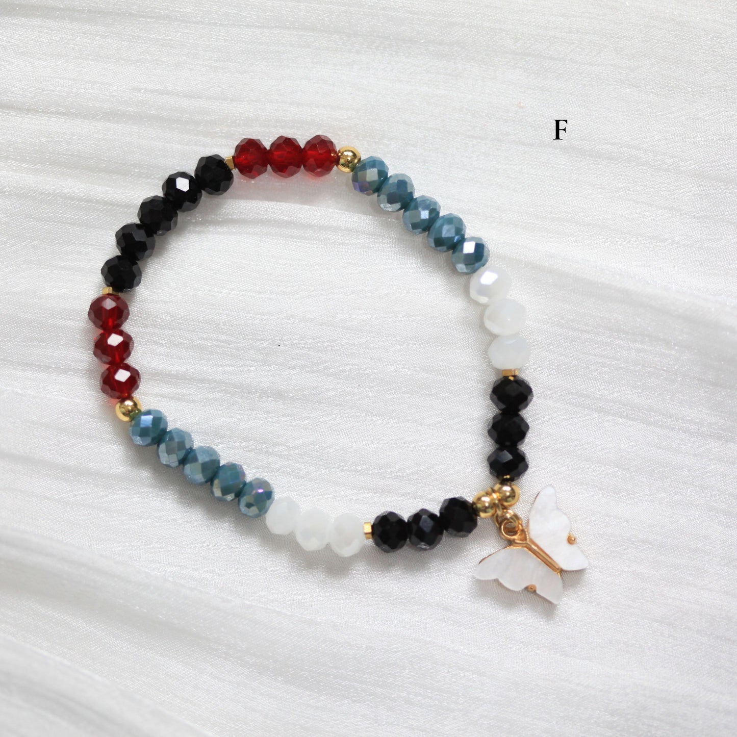 Multicolored tasbih beaded bracelet with a white butterfly charm on a white background