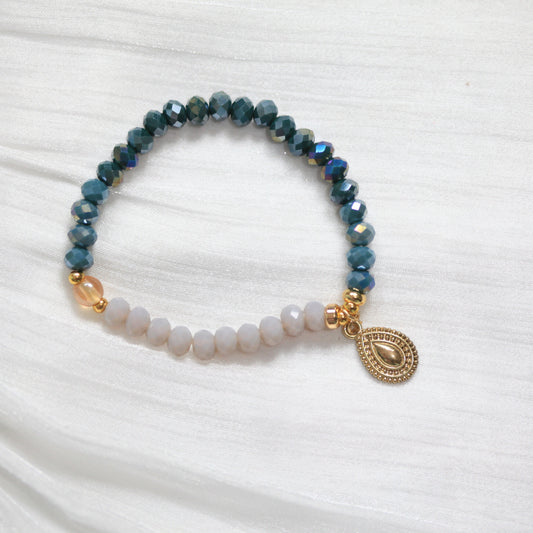 Tasbih Beaded bracelet with a gold charm on a white fabric background