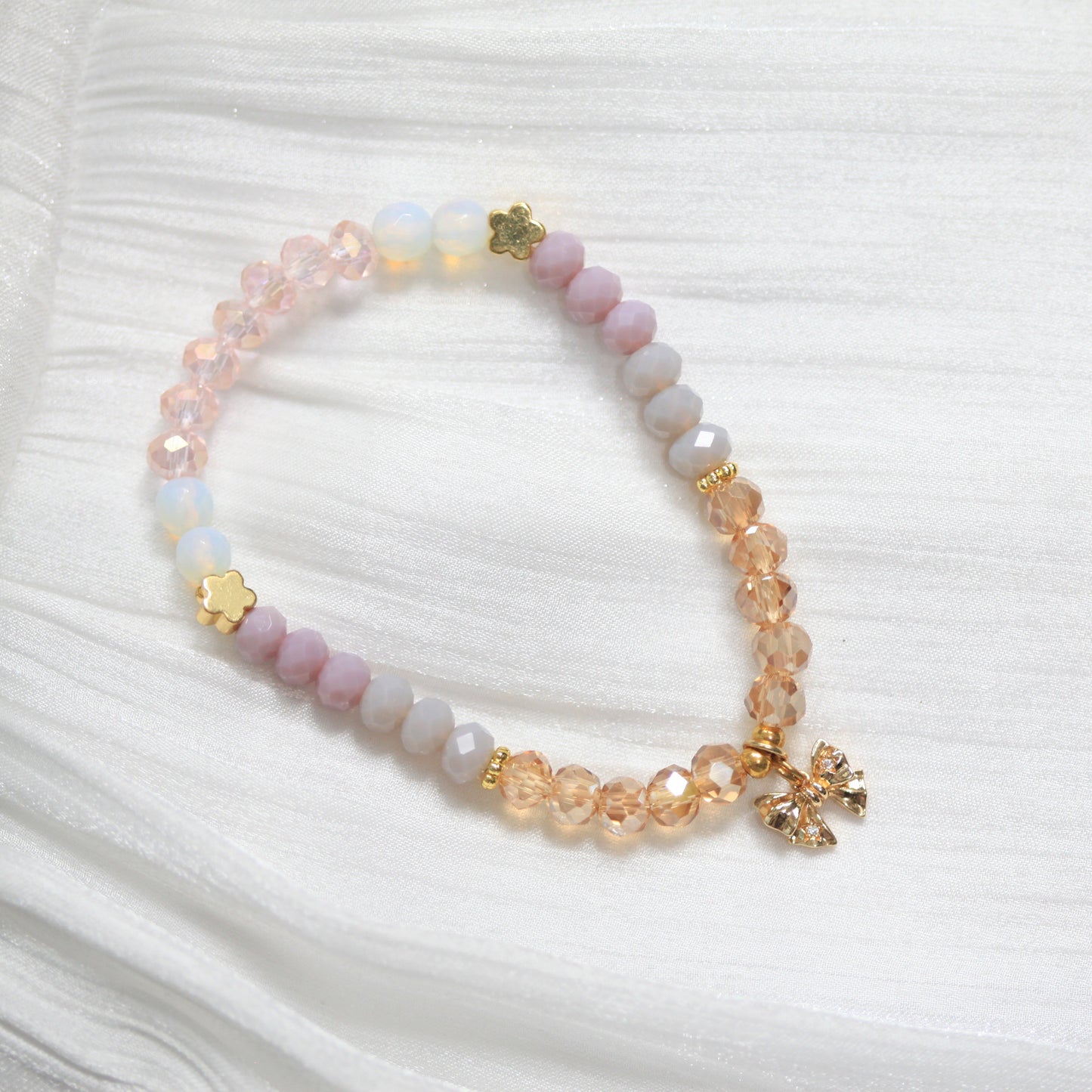 Tasbih Beaded bracelet with floral charms on a white textured background