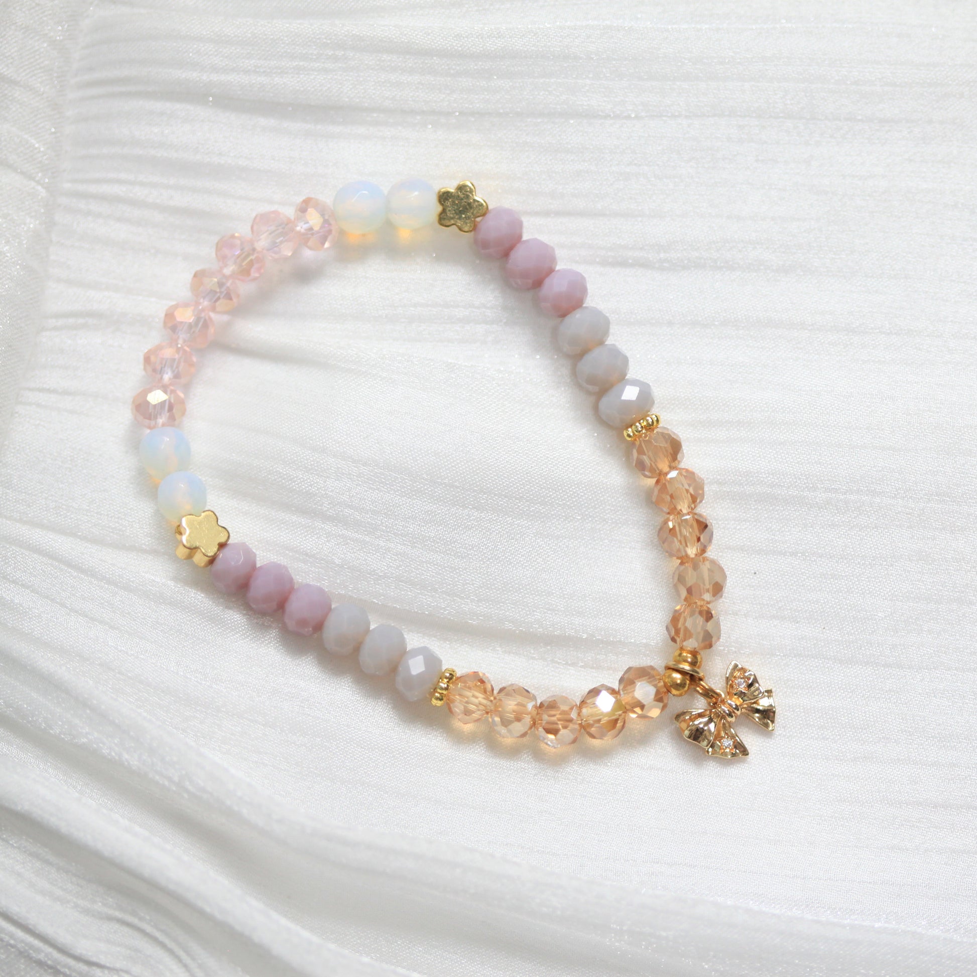 Tasbih Beaded bracelet with floral charms on a white textured background