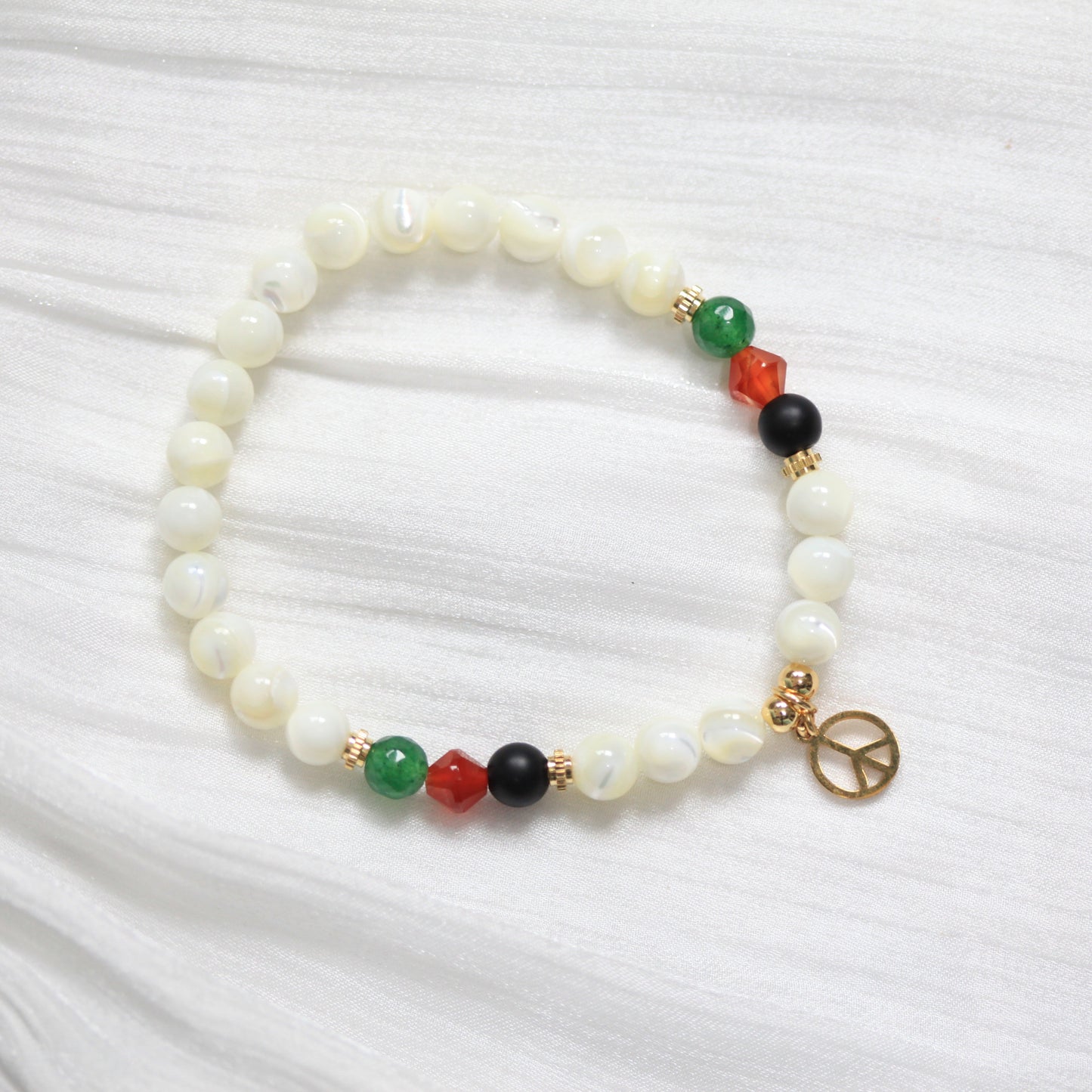 Tasbih Bracelet with multicolored beads on a white fabric background