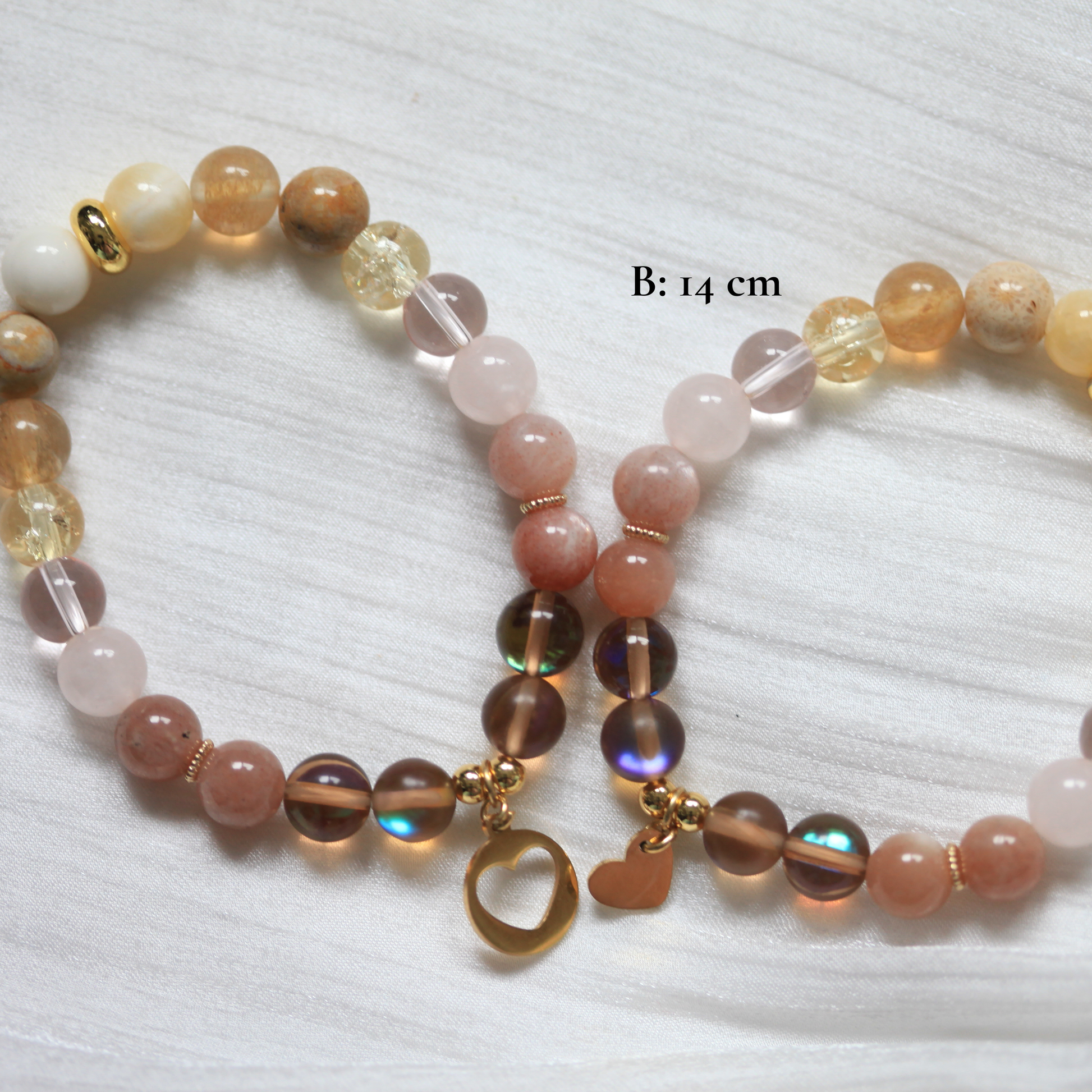 Beaded matching bracelet with multicolored beads and a gold charm on a white background