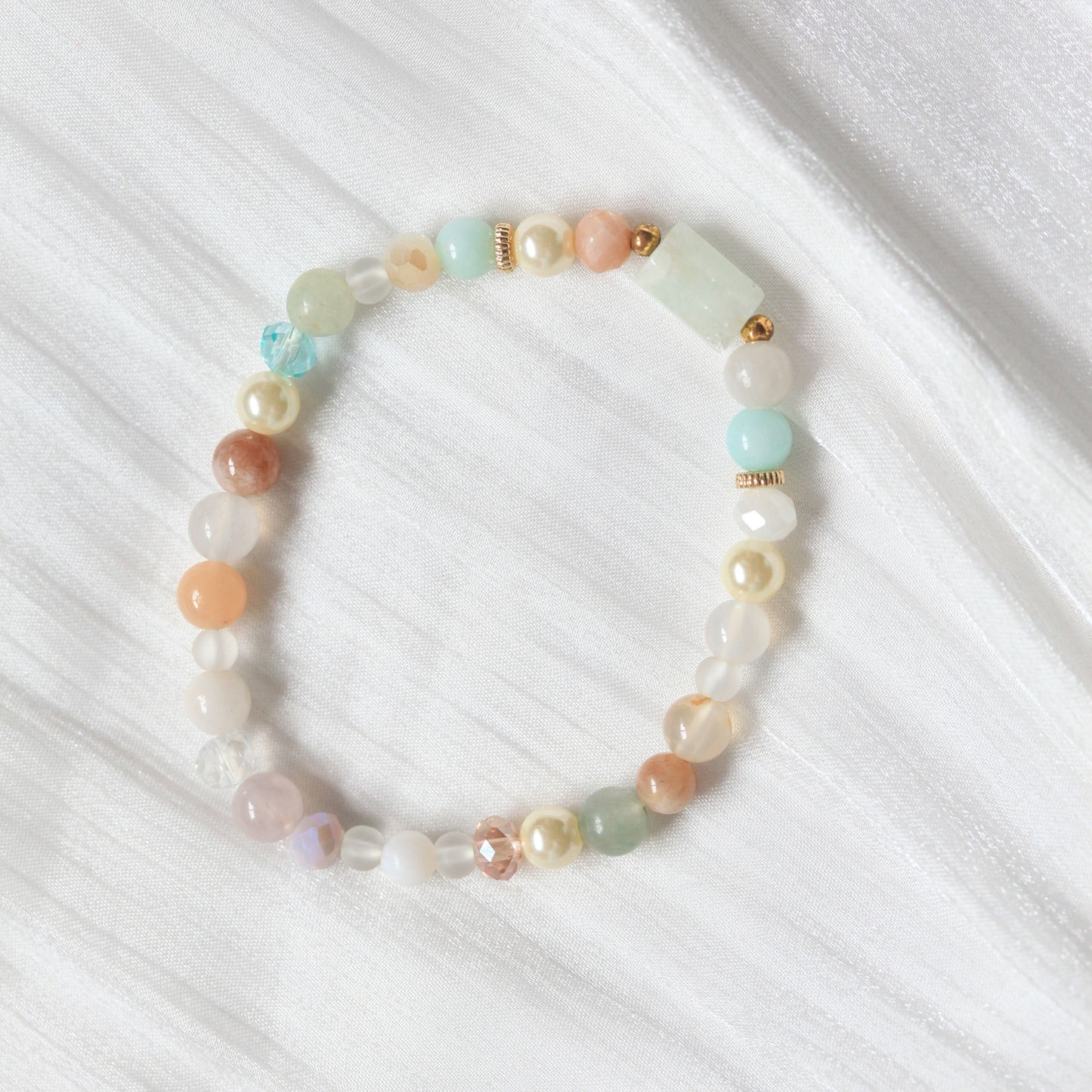 Multicolored beaded bracelet on a white fabric background