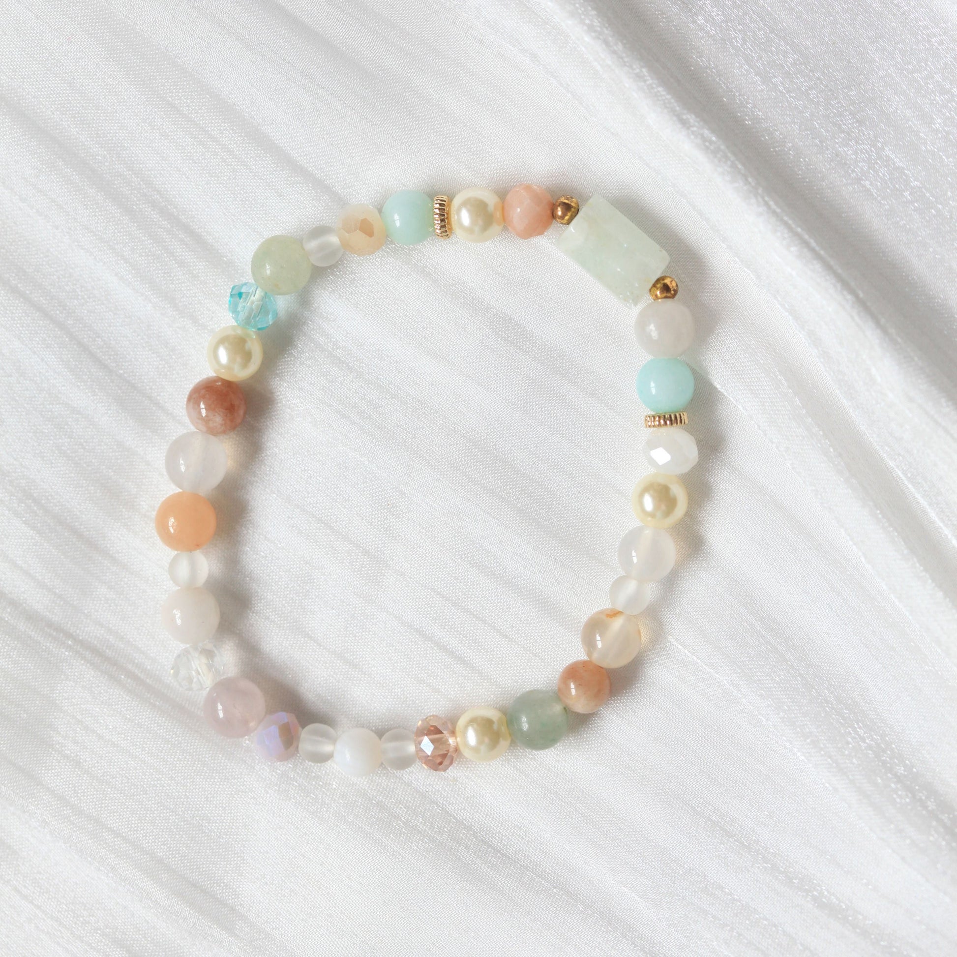 Multicolored beaded bracelet on a white fabric background