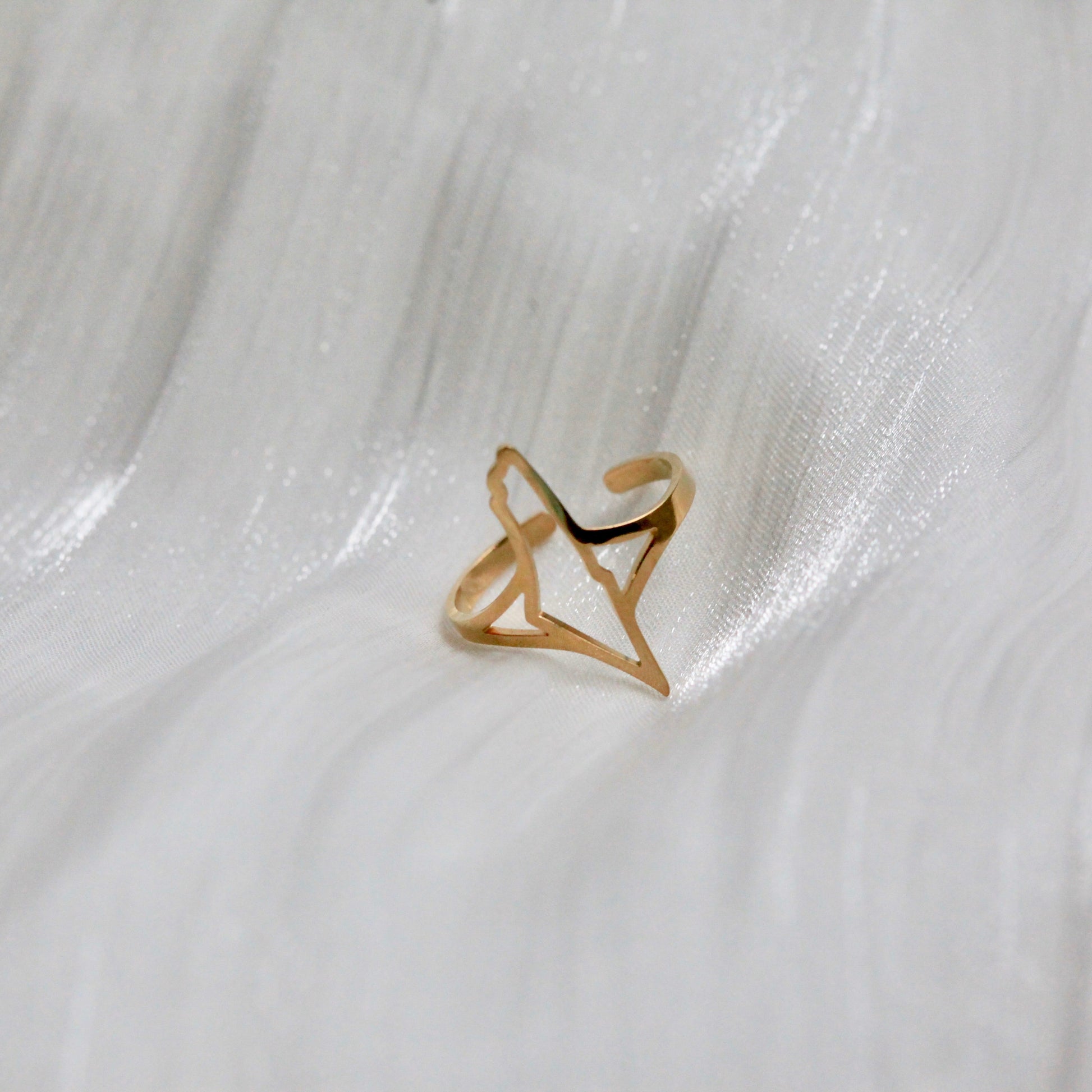 Gold falasteen ring with a unique map design on a white marble surface