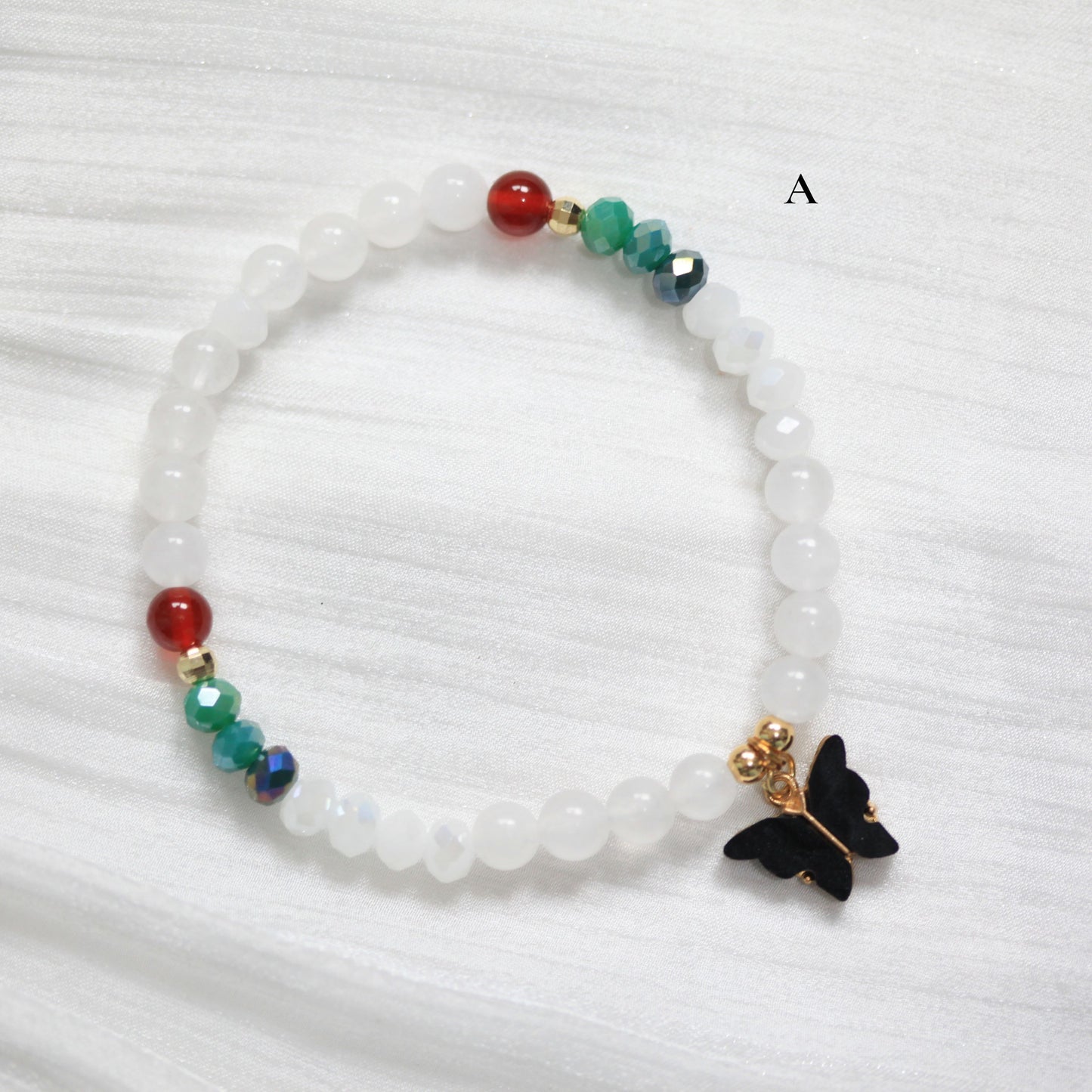 Tasbih Beaded bracelet with a butterfly charm on a white background