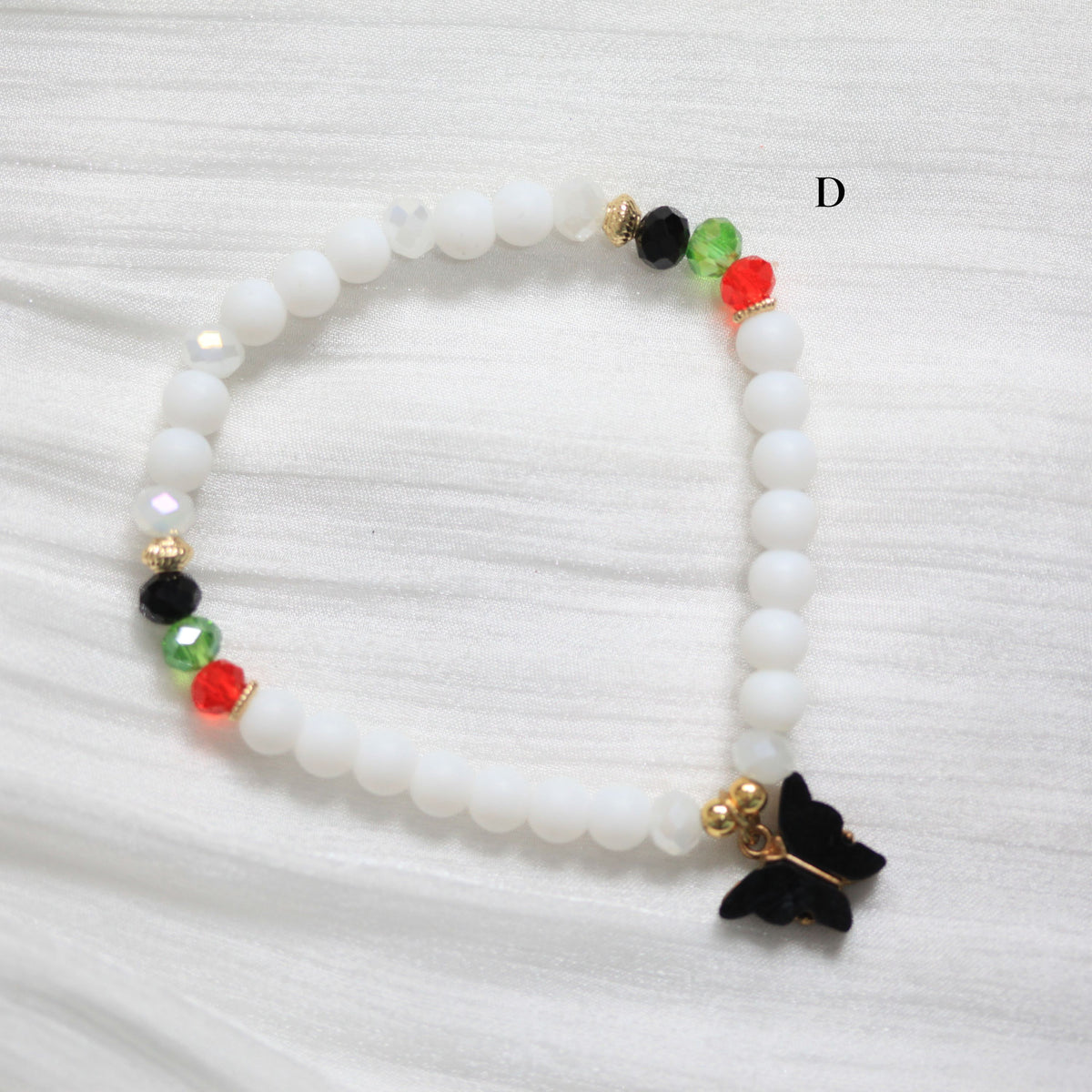 Tasbih Beaded bracelet with a black butterfly charm on a white background