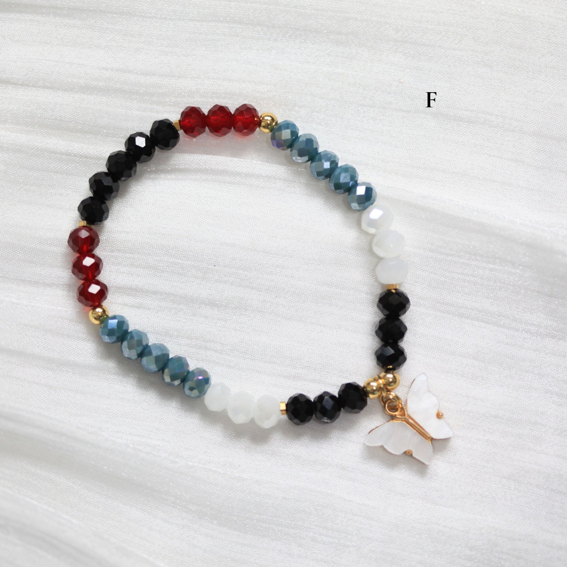 Multicolored tasbih beaded bracelet with a white butterfly charm on a white background