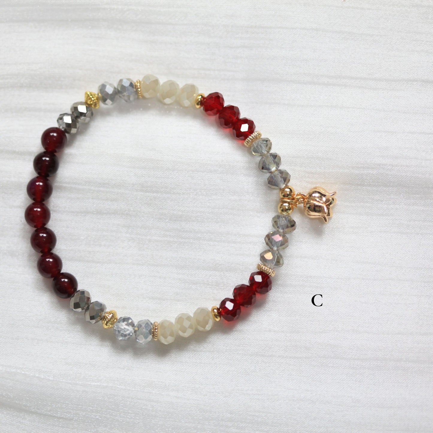 Beaded tasbih bracelet with red and gray beads on a white background