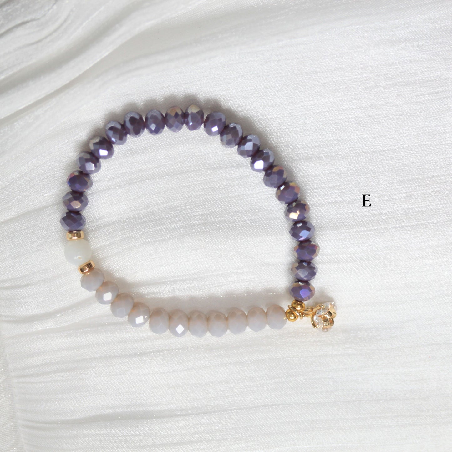 Tasbih Beaded bracelet with purple and white beads on a white fabric background