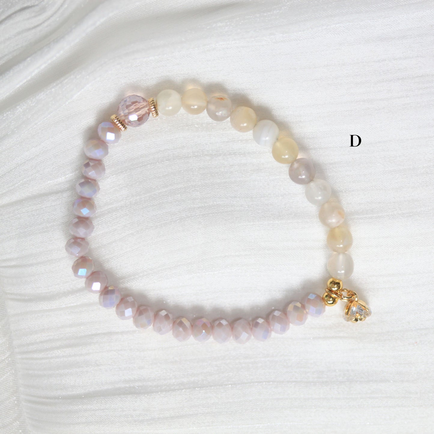 Beaded bracelet with a gold clasp on a white fabric background