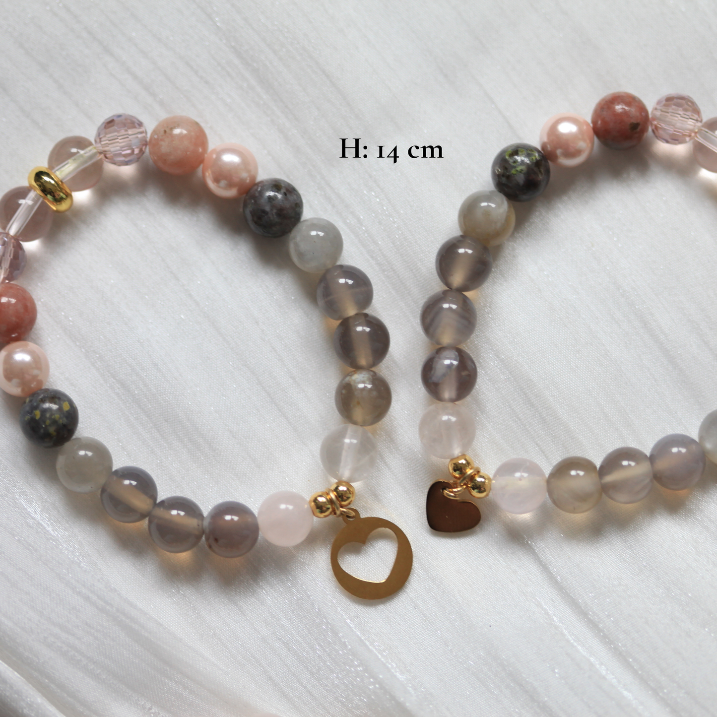 Beaded bracelets with heart charm on a white surface