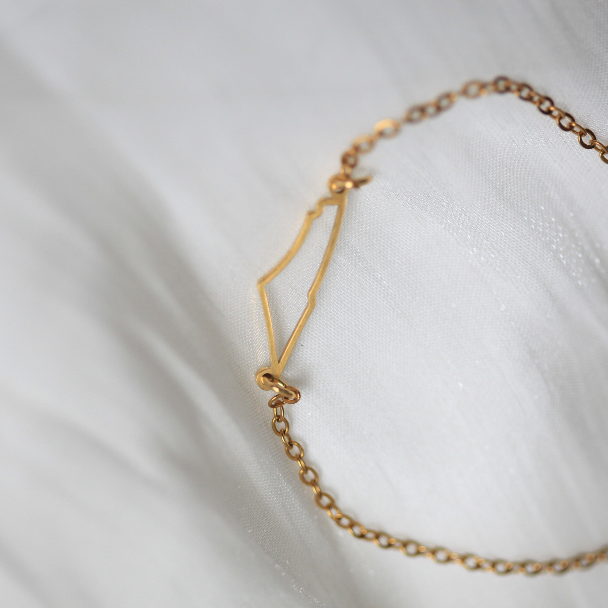 Gold bracelet on a white fabric background
