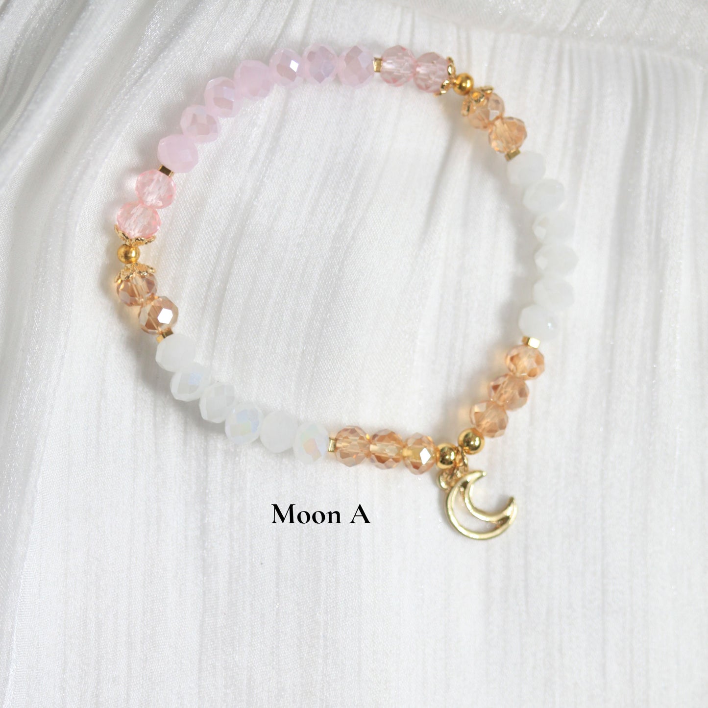 Tasbih Beaded bracelet with pink and gold elements on a white fabric background