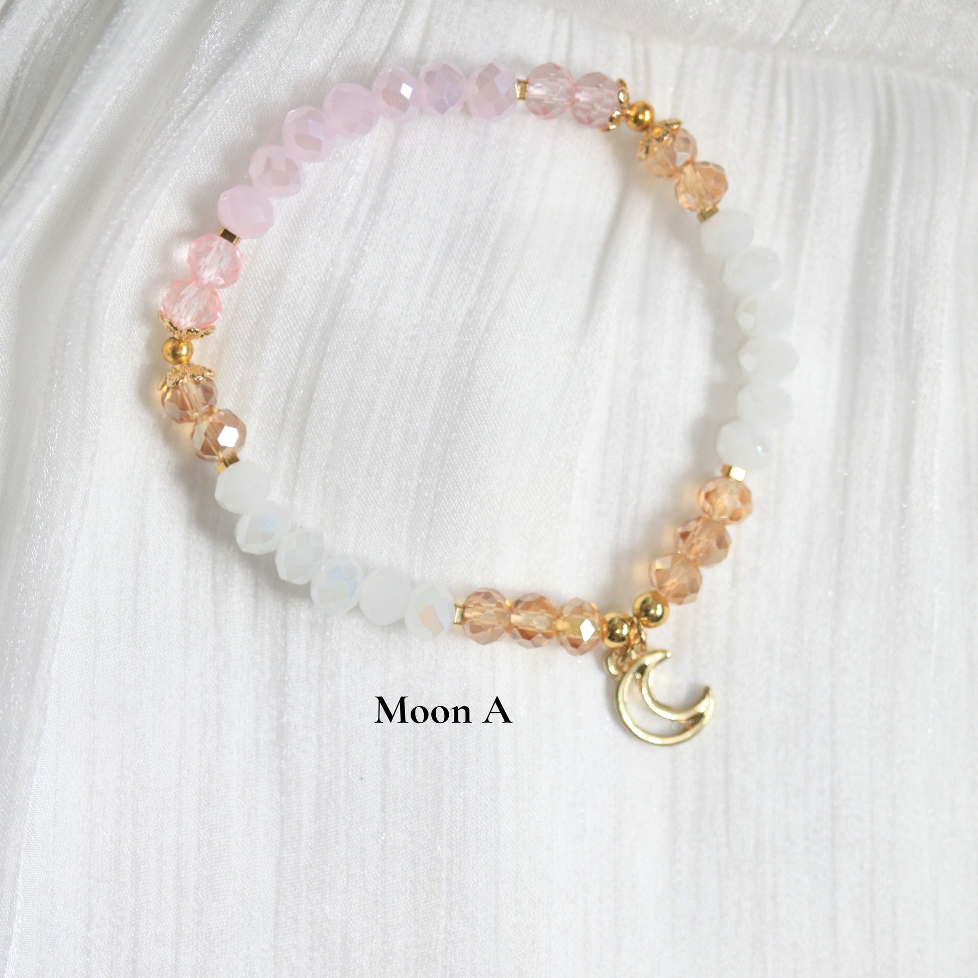 Tasbih Beaded bracelet with pink and gold elements on a white fabric background