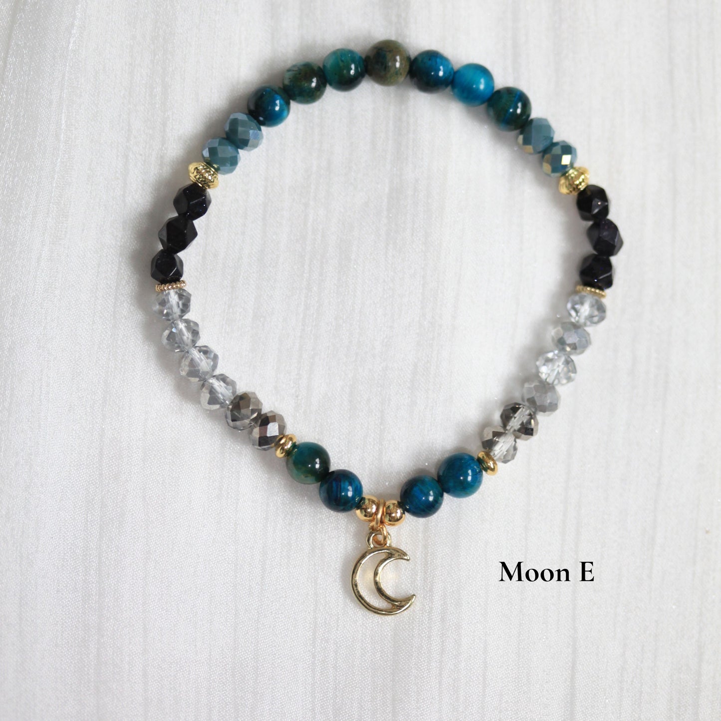 Beaded tasbih bracelet with a moon charm on a white background