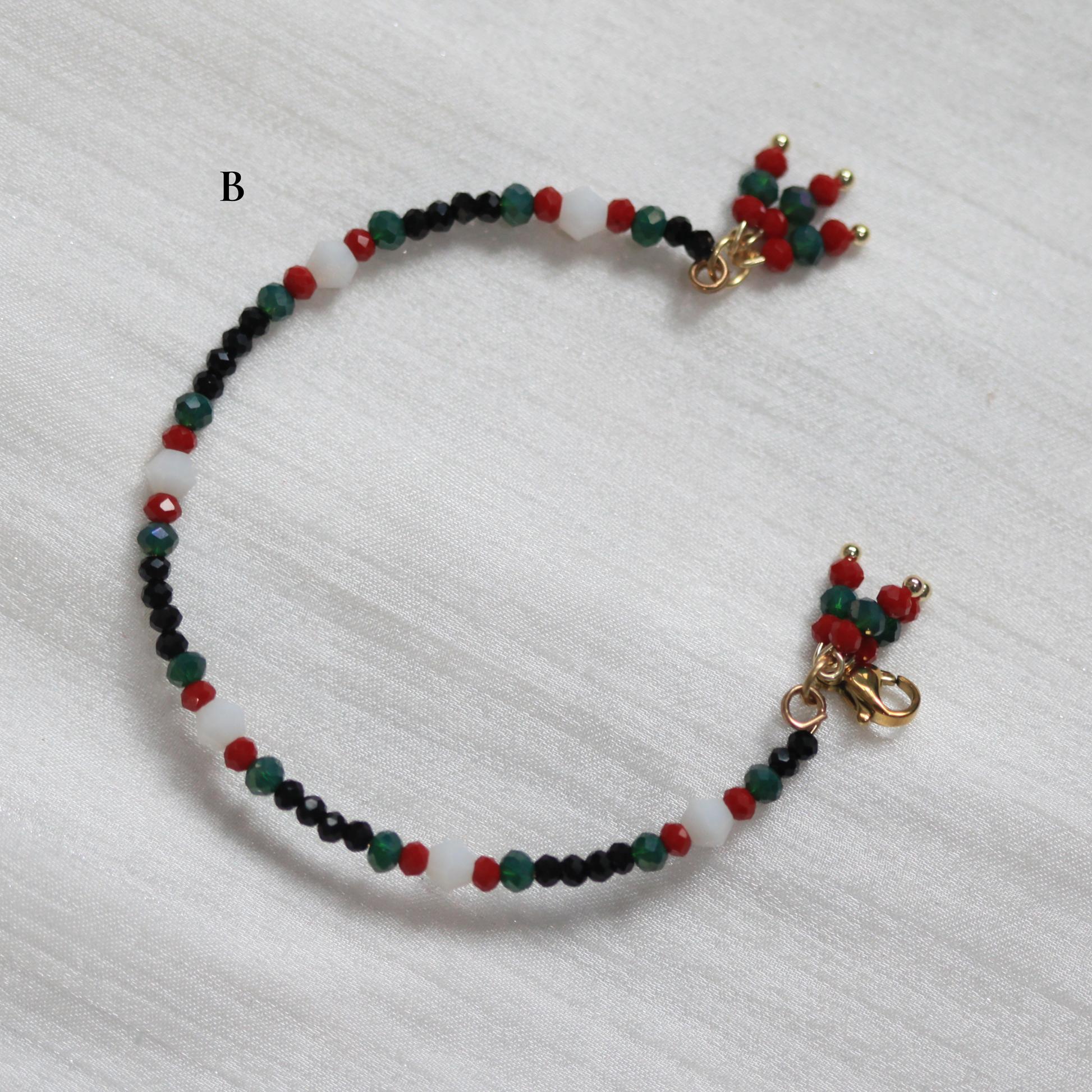 Beaded cuff bracelet with gold clasp on a white background. Tatreez inspired.